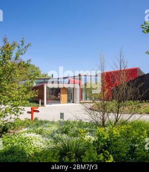 Vue générale avec aménagement paysager. Maggie's Centre, Royal Marsden Hospital, Sutton, Royaume-Uni. Architecte : AB Rogers Design, 2019. Banque D'Images