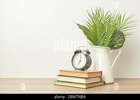 Réception avec vue sur l'horloge, les livres et l'usine sur une table murale blanche. Copier l'espace Banque D'Images