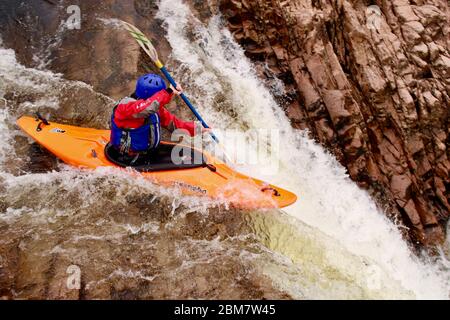 Femelle kayak de l'université pagayant au-dessus d'une cascade (Triple Step) dans un kayak Z-one sur la rivière Etive, Glen COE, Scottish Highlands, Écosse, Royaume-Uni Banque D'Images