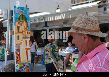 Artiste dans les rues de Positano, peignant une photo du dôme en mosaïque de majolica de la Collégiale de Santa Maria Assunta, Italie Banque D'Images