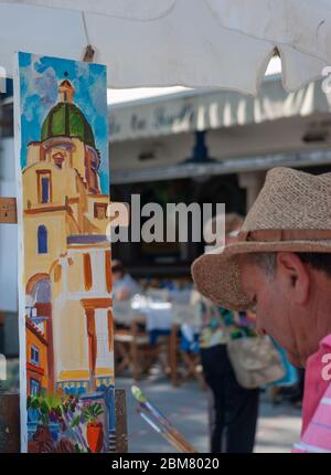 Artiste dans les rues de Positano, peignant une photo du dôme en mosaïque de majolica de la Collégiale de Santa Maria Assunta, Italie Banque D'Images