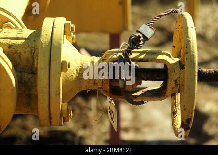 Un tuyau de gaz jaune avec une vanne ronde en Russie sur le fond d'un mur de bâtiment. Technologie industrielle du gazoduc. Banque D'Images