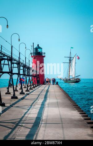 Un grand bateau naviguant devant une maison de lumière lors d'une journée d'été à South Haven Michigan Banque D'Images