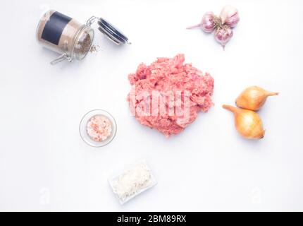 ingrédients pour la cuisson des côtelettes de viande hachée, isolées sur blanc, poivre, sel, oignon, ail. Vue de dessus. Gros plan Banque D'Images