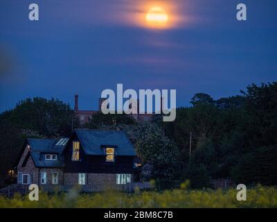 Eastchurch, Kent, Royaume-Uni. 7 mai 2020. Météo britannique : la pleine lune de fleurs s'élève au-dessus de l'historique Shurland Hall à Eastchurch, dans le Kent. Crédit : James Bell/Alay Live News Banque D'Images