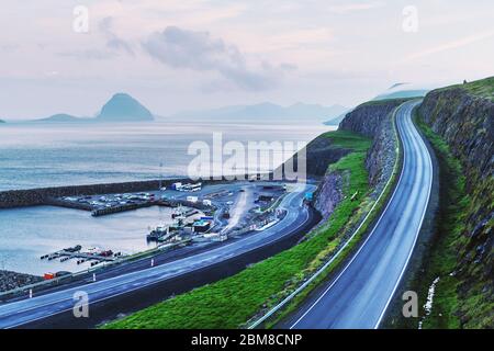 Vue du matin sur un quai avec des voitures et des bateaux près du village de Velbastadur sur l'île de Streymoy, îles Féroé, Danemark. Photographie de paysage Banque D'Images