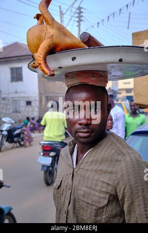 Portrait d'un vendeur de rue portant un plateau avec une tête de bélier dans les rues du marché de Kano. Banque D'Images
