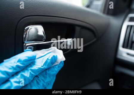 Nettoyage de la poignée de porte de voiture avec de l'assainisseur essuyez l'infection virale Banque D'Images