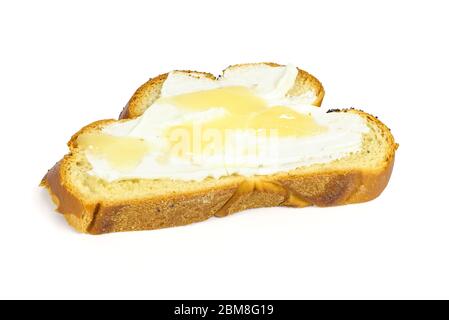 Tranche de pain de challah avec fromage cottage et miel isolé sur fond blanc avec passe-cheveux Banque D'Images