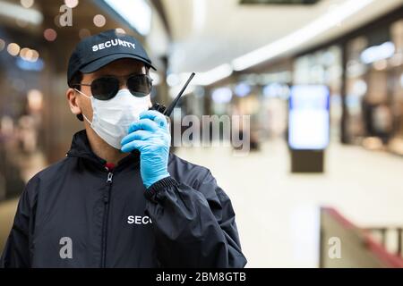 Garde de sécurité utilisant Walkie Talkie dans le centre commercial Banque D'Images