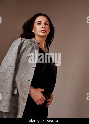 Portrait de la jeune femme d'affaires merveilleuse sur fond gris avec espace de copie. Banque D'Images