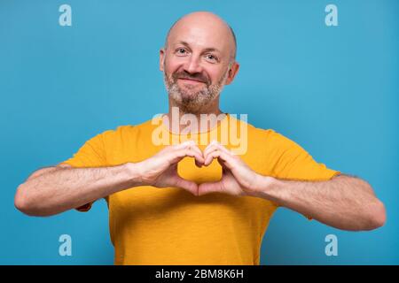 Beau homme faisant un coeur avec ses mains Banque D'Images