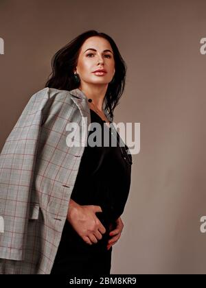 Portrait de la jeune femme d'affaires merveilleuse sur fond gris avec espace de copie. Banque D'Images