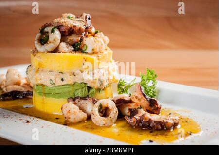 Plat péruvien traditionnel appelé Causa fait de purée de pommes de terre avec le piment et le jus de lime aji et rempli de légumes maïs, pois, carottes et Banque D'Images