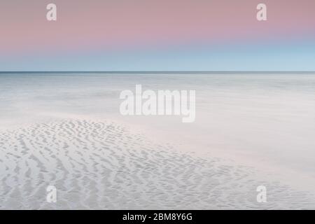 Un ciel pastel à l'aube au-dessus de la plage de sable blanc de Dunsborough, en Australie occidentale Banque D'Images