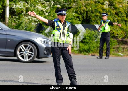 Des policiers ont dirigé la circulation à l'écart d'un incident de police sur Barnsdale Road à Allerton Bywater, West Yorkshire UK, après un renversement de véhicule. Banque D'Images