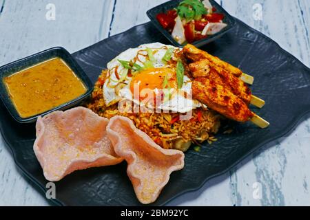 Nasi goreng, littéralement du riz frit en indonésien, servir avec du poulet, des crevettes etc Banque D'Images