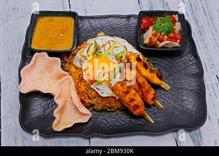 Nasi goreng, littéralement du riz frit en indonésien, servir avec du poulet, des crevettes etc Banque D'Images