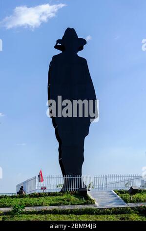 Nicaragua, Amérique centrale, Managua. Homme en noir, Augusto Sandino , général nigaraguan, avec des sculptures d'arbre de vie. Banque D'Images