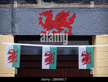 Banderole galloise traditionnelle et dragon gallois rouge sur la porte à Penmachno, Penmachno, Snowdonia, au nord du pays de Galles, Royaume-Uni Banque D'Images