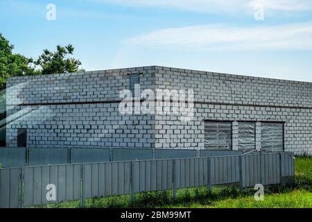 Le bâtiment est fait de bloc de mousse blanche et d'une clôture en métal gris. Banque D'Images