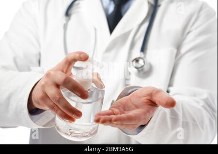 Vue rapprochée, du médecin en cabinet médical, se lavant les mains avec du gel hydroalcoolique. Prévention de la covid19. Épidémie de coronavirus . Banque D'Images