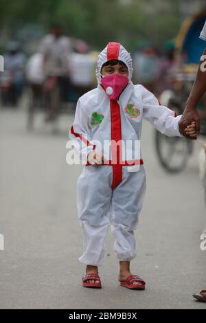 Dhaka, Bangladesh - 03 mai 2020 : un garçon bangladais porte un vêtement de protection car ses parents prennent des précautions pour le protéger contre la COVID-19, à Dhaka, Bangla Banque D'Images