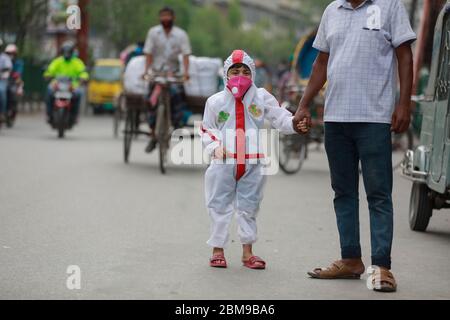 Dhaka, Bangladesh - 03 mai 2020 : un garçon bangladais porte un vêtement de protection car ses parents prennent des précautions pour le protéger contre la COVID-19, à Dhaka, Bangla Banque D'Images