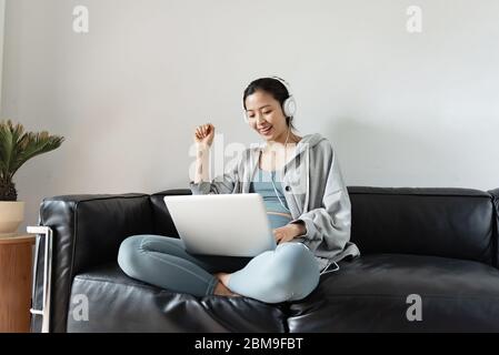 Une jeune femme asiatique utilisant un ordinateur dans le salon Banque D'Images