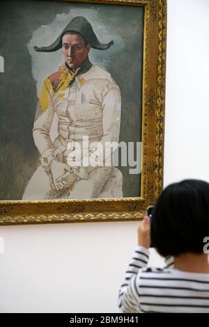 Le dessin de Pablo Picasso exposition d'Arlequin assis au Centre Pompidou avec un enfant prenant la photo d'un téléphone portable en premier plan.Paris.France Banque D'Images