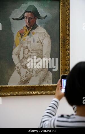 Le dessin de Pablo Picasso exposition d'Arlequin assis au Centre Pompidou avec un enfant prenant la photo d'un téléphone portable en premier plan.Paris.France Banque D'Images
