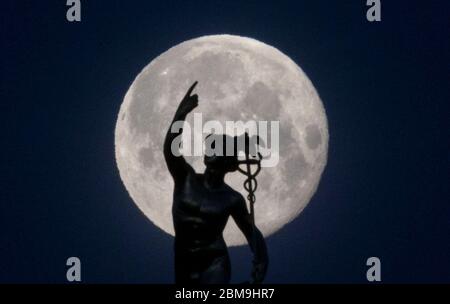 Stuttgart, Allemagne. 08e mai 2020. La statue de Mercure du sculpteur Ludwig von Hofer, au sommet de la Tour du Mercure, au centre-ville, se distingue contre la lune. Credit: Marijan Murat/dpa/Alay Live News Banque D'Images