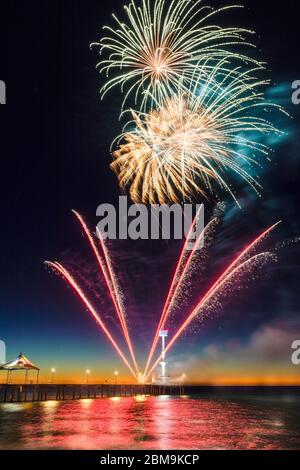 Feu d'artifice du nouvel an coloré illuminez le ciel et l'eau au large de Brighton Jetty, Adélaïde, Australie méridionale Banque D'Images