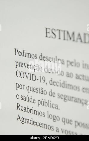 Faro, Portugal - 16 mars 2020 : message imprimé sur la fenêtre d'un magasin écrit en portugais informant les gens de la fermeture en raison de l'épidémie de coronavirus COVID-19. Pandémie de COV-SRAS-2. Banque D'Images