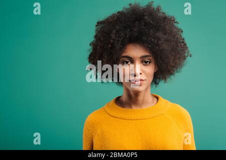 Portrait d'une jeune femme africaine portant un chandail isolé sur fond vert Banque D'Images