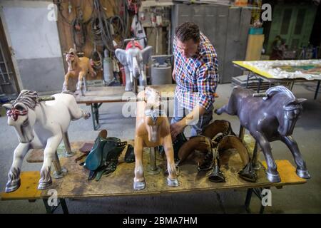 28 avril 2020, Bavière, Burgthann : le showman Johannes Braun se tient dans son atelier à côté de figures de carrousel restaurées. Il a été habitué à être un showman depuis qu'il était un enfant. Braun dirige l'entreprise familiale de la 7e génération avec sa mère. En fait, Johannes Braun et sa famille sont sur la route depuis des mois. Avec des voitures tamponneuses et un carrousel pour enfants, ils voyagent de la foire à la foire. Mais en raison de la crise de la couronne, Braun est actuellement incapable de travailler et craint maintenant pour son existence. (À dpa 'réparations et stand de bonbons au lieu de l'agitation du parc d'expositions') photo: Daniel Karmann/ Banque D'Images