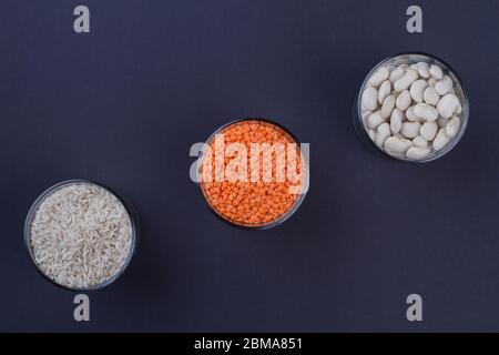 Trois pots en verre avec lentilles de riz et haricots blancs. Banque D'Images