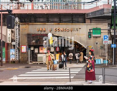 tokyo, japon - mars 25 2020: Une japonaise dans un kimono hakama lisant un guide de voyage au fond rétro Yuraku Concourse de la gare Yurakucho. J Banque D'Images