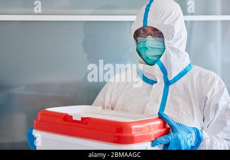 Medic dans des vêtements de protection pendant le transport de don d'organe pour la chirurgie en clinique Banque D'Images