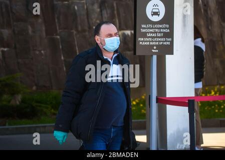 RIGA, LETTONIE. 7 mai 2020. Les passagers portant un masque de protection du visage arrivent à l'aéroport international de Riga. Banque D'Images