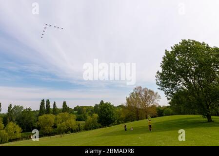 Gloucester Park, Basildon, Essex, Royaume-Uni. 8 mai 2020. L'équipe d'affichage des flèches rouges de la Royal Air Force effectue des flypasts pour les célébrations du 75e anniversaire du VE Day. Décollant de leur base à la RAF Scampton dans le Lincolnshire, l'équipe s'est positionnée au-dessus de la mer du Nord au large de la côte de Norfolk avant de courir au-dessus de Norfolk, Suffolk et Essex sur le chemin de Westminster à Londres et de retour à la maison. Vu passer au-dessus de Gloucester Park, Basildon, Essex avec la famille regarder Banque D'Images