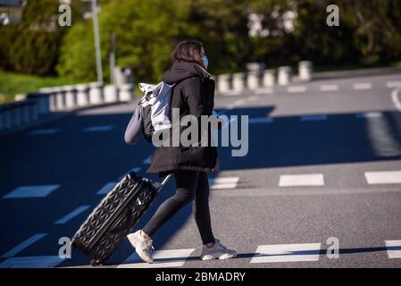 RIGA, LETTONIE. 7 mai 2020. Les ouvriers des bus portant des costumes de protection et des masques de protection du visage attendent les passagers à leur arrivée à l'aéroport international de Riga. Banque D'Images