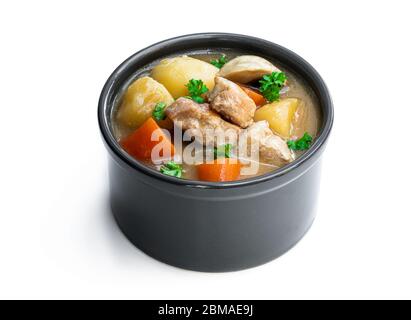 Porc cuit avec des légumes dans un petit pot d'argile isolé sur blanc Banque D'Images