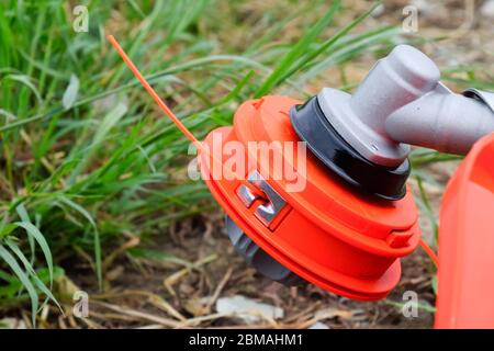 Tête avec ligne de pêche pour faucher l'herbe. Tondeuse à gaz. Gascose trimère avec une feuille pour faucher l'herbe et les arbustes. Banque D'Images