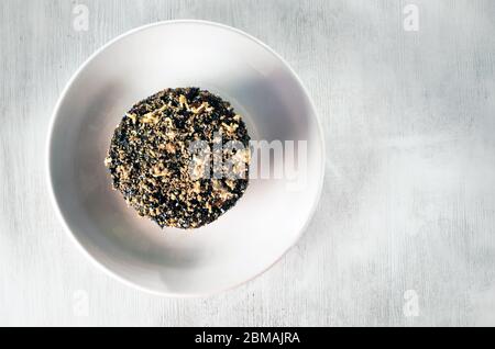 Gâteau sucré arrosé de noix sur une assiette blanche et une table en bois texturée Banque D'Images