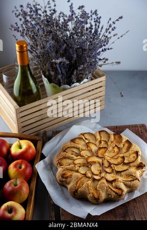 Tarte ronde maison avec pommes sur une table en bois. . Pâte simple à base de pâte à croûte courte et pomme caramélisée. Pâtisseries sucrées. La vie est encore avec Banque D'Images