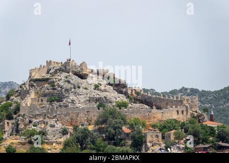 Kalekoy, Simena , Turquie - 03 juin 2019 : village de Kalekoy avec maisons en pierre et château au sommet de la colline dans la baie d'Uchagiz en Turquie, près de la ville en contrebas Banque D'Images