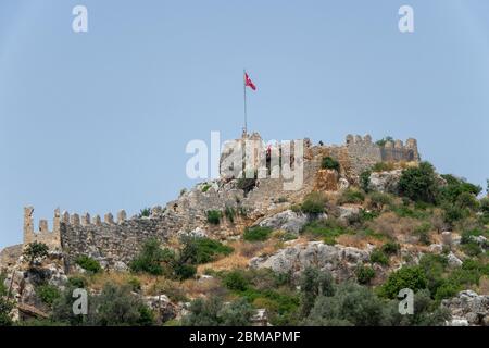 Kalekoy, Simena , Turquie - 03 juin 2019 : village de Kalekoy avec maisons en pierre et château au sommet de la colline dans la baie d'Uchagiz en Turquie, près de la ville en contrebas Banque D'Images