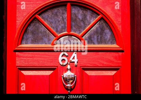 Maison numéro 64 sur une porte en bois rouge Banque D'Images