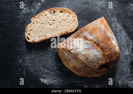 Ambiance sombre et ton maison cuisine maison biologique rustique Sourdough pain sur fond noir avec espace de copie Banque D'Images